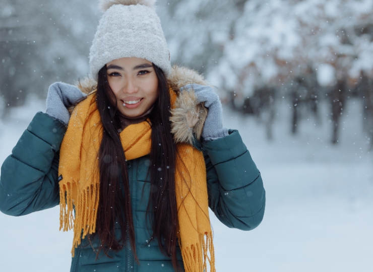 Meisje in de sneeuw met een muts op, dankzij de praktische haarverzorgingstips die ze op de blog van Salon Warrig in Sint Pancras vond.