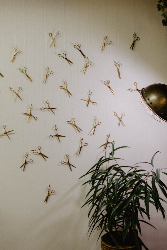 Wand met scharen in kapsalon Salon Warrig in Sint Pancras.